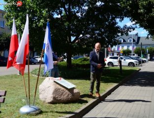 Kwiaty pod pamiątkowym obeliskiem w rocznicę wyzwolenia Mławy